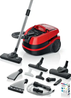 A red and black cylinder vacuum cleaner with various attachments displayed around it on a white background.