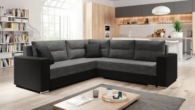 A modern living room with a sectional sofa, coffee table, and kitchen in the background.