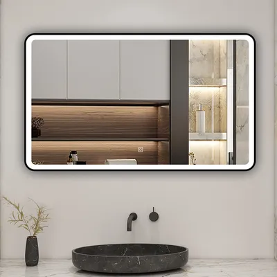 A modern bathroom vanity with a large illuminated mirror above a marble sink.