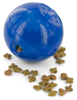 A blue pet treat dispensing ball with kibble scattered around it on a white background.