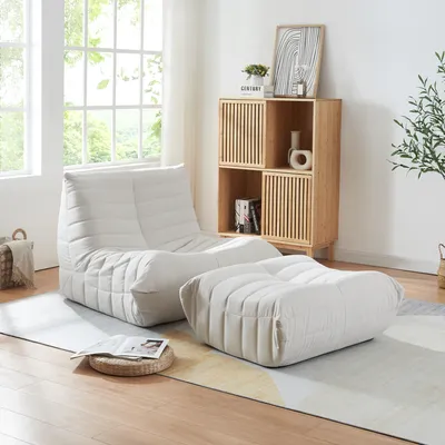 A modern living room with a beige beanbag chair and ottoman set.