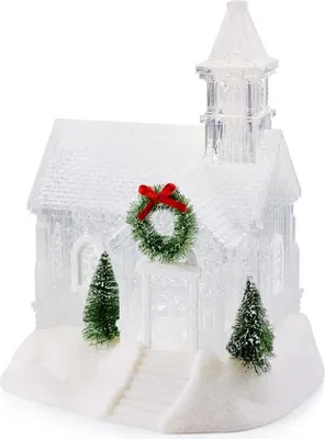 A decorative, snow-covered church with a wreath and Christmas trees, likely a holiday decoration.