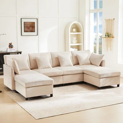 A U-shaped sectional sofa with multiple cushions and ottomans is shown in a well-lit living room setting.