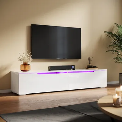 A modern living room with a TV mounted on the wall above a white high-gloss TV stand with purple LED lighting.