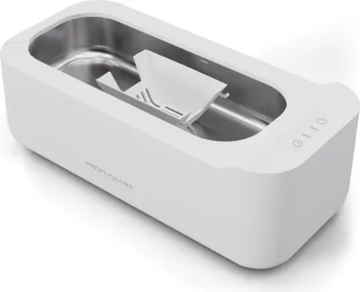 A white ultrasonic cleaning device with a silver interior and a white plastic basket inside.