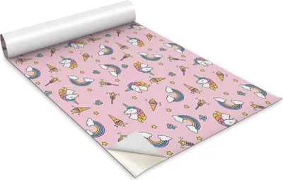 A roll of wrapping paper with a pink background and a pattern of unicorns, ice cream cones, rainbows, and stars.