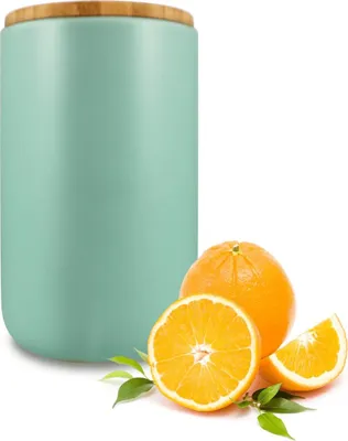 A turquoise ceramic storage jar with a wooden lid, accompanied by whole and sliced oranges and green leaves, set against a white background.