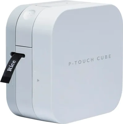 A white Brother P-touch Cube label maker sits on a white background with a black label extending from the side.