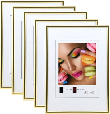 A stack of gold picture frames with white mats, one of which displays a close-up image of a woman's face with colorful eye makeup and macarons.