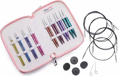 A set of knitting needles and accessories laid out on a white background.