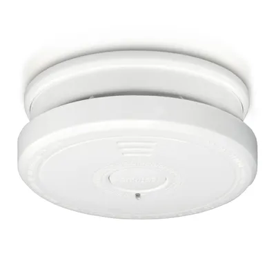 A white smoke detector is mounted on a white ceiling.