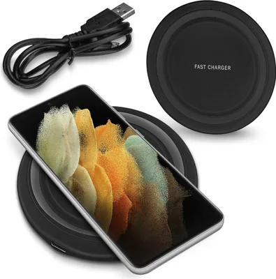 A smartphone is placed on a wireless charging pad, with a USB cable nearby.