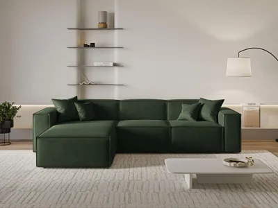 A modern living room with a green sectional sofa, shelves, and a floor lamp.