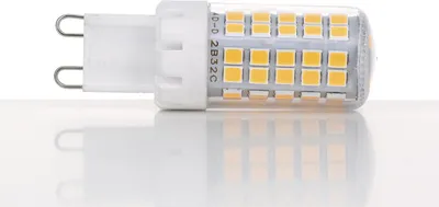 A close-up studio shot of an LED light bulb with a G9 base, resting on a reflective white surface.