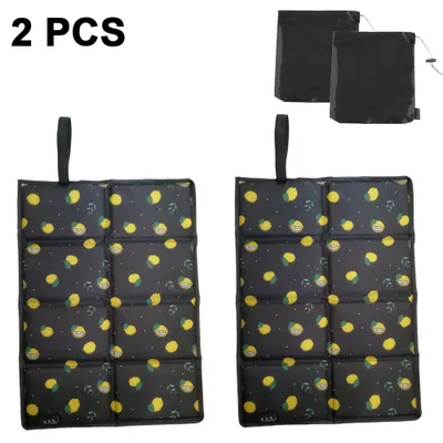 Two foldable outdoor seat cushions with a lemon pattern are displayed, along with two black storage bags.