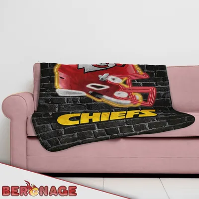A blanket with the Kansas City Chiefs logo is draped over a couch.