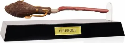 A Harry Potter Firebolt broomstick pen displayed on a black stand with a gold plaque.