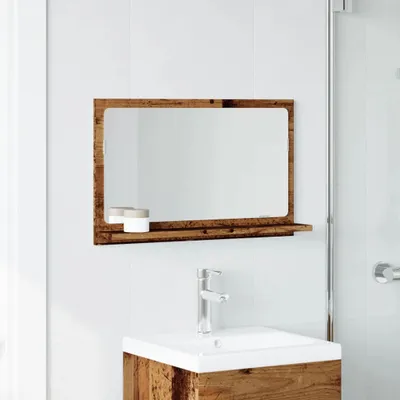 A bathroom mirror with a wooden frame and shelf is mounted above a sink with a chrome faucet.