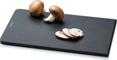 A dark cutting board with two whole mushrooms and three sliced mushrooms on it.