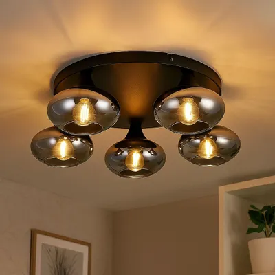 A close-up view of a black, five-light ceiling lamp with smoked glass shades, mounted on a ceiling.
