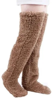 Paar braune flauschige Overknee-Socken an Beinen, vor weißem Hintergrund