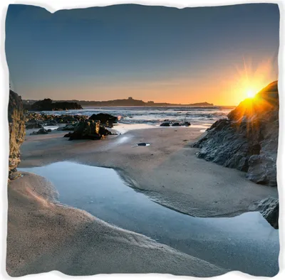 Produktbild von Wallario Premium Kissen, weiche Oberfläche, mit Motiv Sonnenuntergang hinter einem Felsen am Strand, Größe: 40 x 40 cm, mit weißer Rückseite