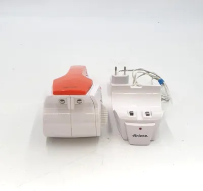 Two white electrical appliances with orange accents are placed on a white surface.