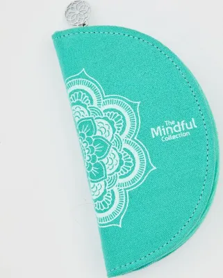 A teal colored pouch with a white mandala pattern and text.