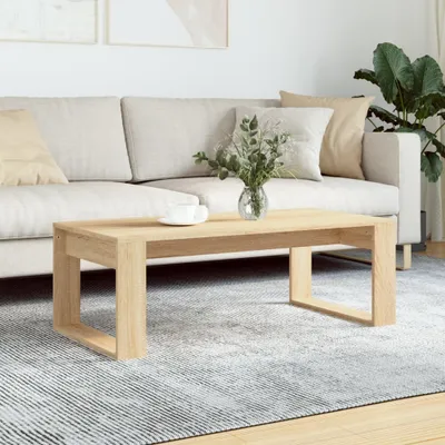 A modern living room scene with a couch, coffee table, and plant.