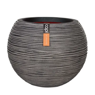 A round, textured planter pot with a label attached.