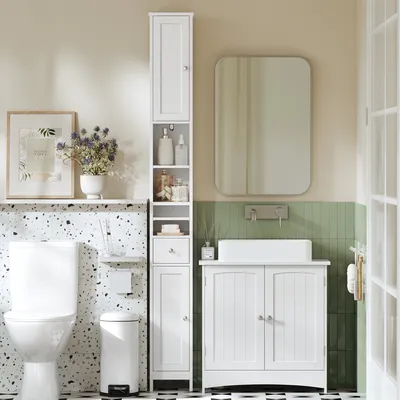 A clean and organized bathroom scene featuring a white storage cabinet, toilet, sink, and mirror.
