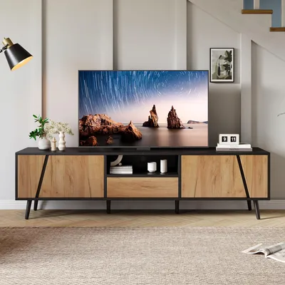 A modern living room with a TV stand, television, and decor.