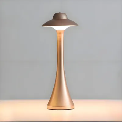 A rose gold colored LED table lamp with a mushroom-shaped shade is shown on a white surface against a light gray background.