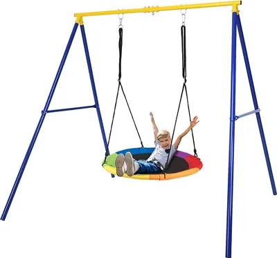 A child is swinging on a colorful nest swing attached to a yellow and blue swing set.