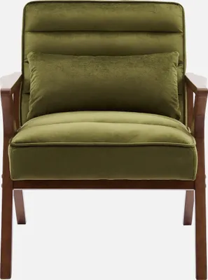 A studio shot of a green velvet armchair with wooden legs.