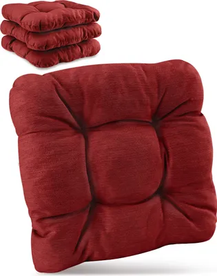 A stack of red seat cushions in the background and one in the foreground.