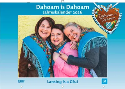Three women smiling and embracing, with a decorative gingerbread heart in the background.