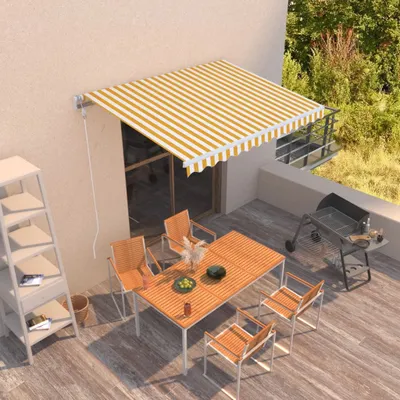 A balcony with a table, chairs, and a grill, shaded by a striped awning.