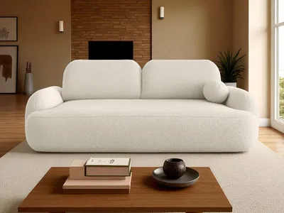 A cream-colored sofa is placed in a living room setting, with a coffee table in front of it.