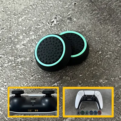 Two black and light green thumbstick grips for a game controller are shown on a textured gray surface. Insets show the bottom of a game controller and a white game controller with colored buttons.