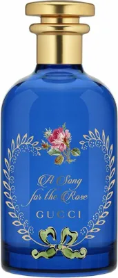 A blue glass perfume bottle with a gold cap and decorative floral label.