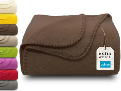 A folded brown fleece blanket is shown, with a stack of other colored blankets on the left. A tag is attached to the blanket.