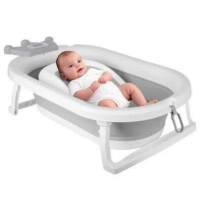 A baby is lying in a foldable baby bathtub.
