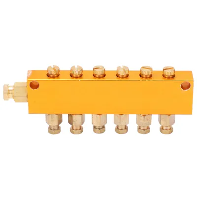 A product shot of a brass oil distributor with multiple outlets, isolated on a white background.