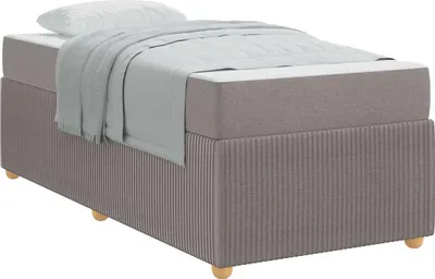 A taupe bed frame with a mattress and a gray blanket is shown against a white background.