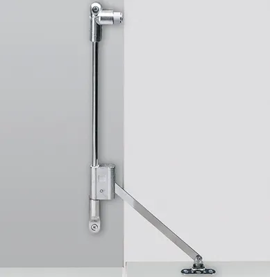 A metal door closer mechanism mounted on a wall and a door frame.