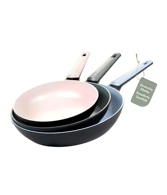Three frying pans of different sizes stacked on top of each other, with a tag attached to the handle of the largest pan.