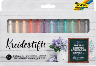 A box of chalk pencils with a decorative background of flowers and a small chalkboard.