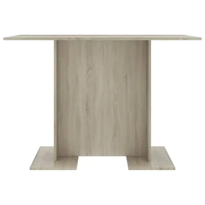 A front view of a light brown wooden dining table with a pedestal base.