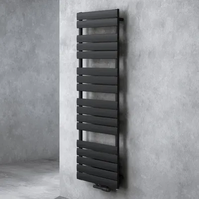 A black radiator is mounted on a textured gray wall.